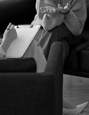 Сеанс индивидуальной терапии: психолог с блокнотом беседует с клиентом